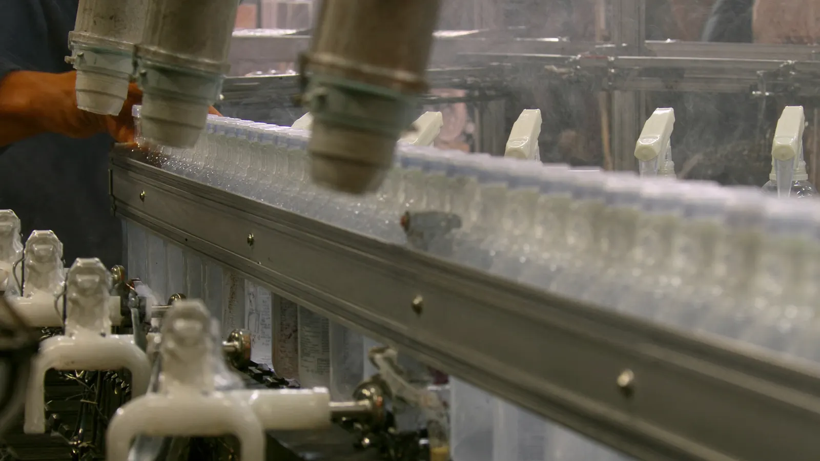 Spray bottles moving through a capping station