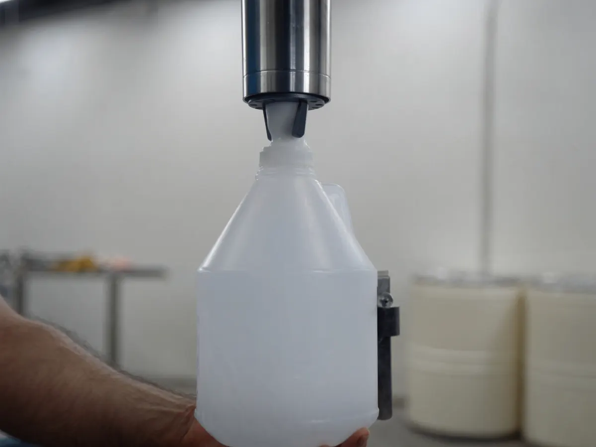 A jug held under a filling nozzle