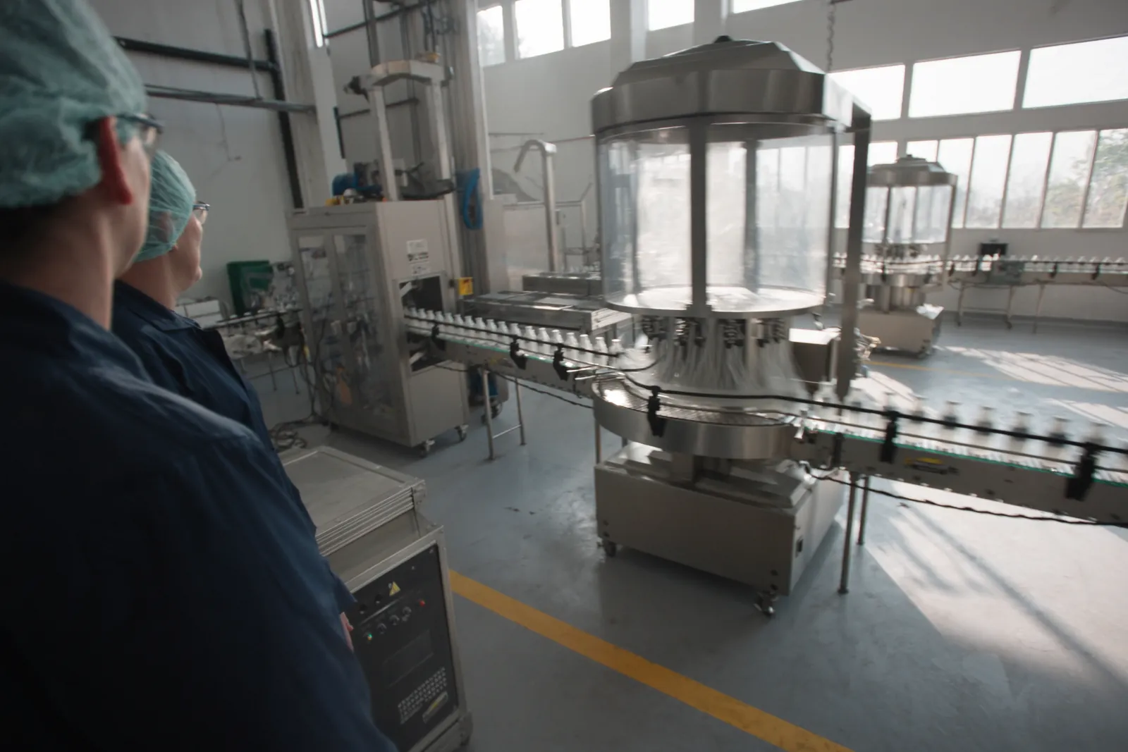 Operators checking a filling line in a bright plant